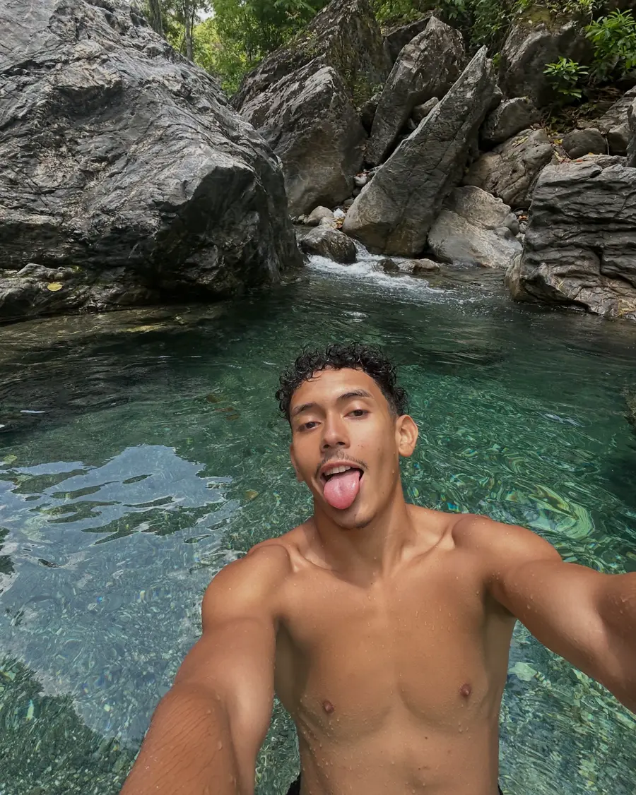 Selfie de Dani dentro de un pozo de agua verde entre rocas.