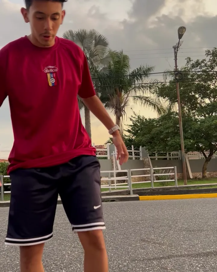 Dani con franela vinotinto de Venezuela en una calle de Acarigua al atardecer.