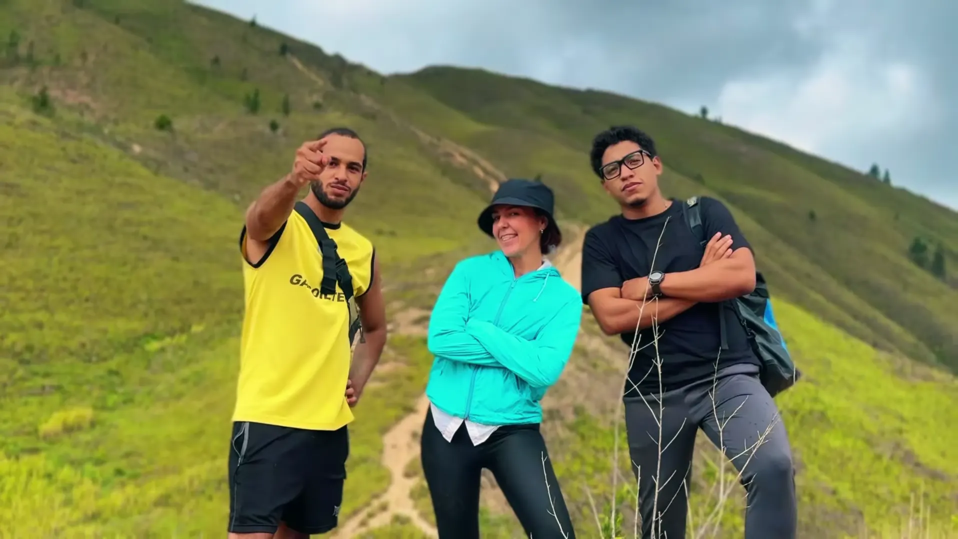 Caricuao: tres creadores posan en una montaña verde.
