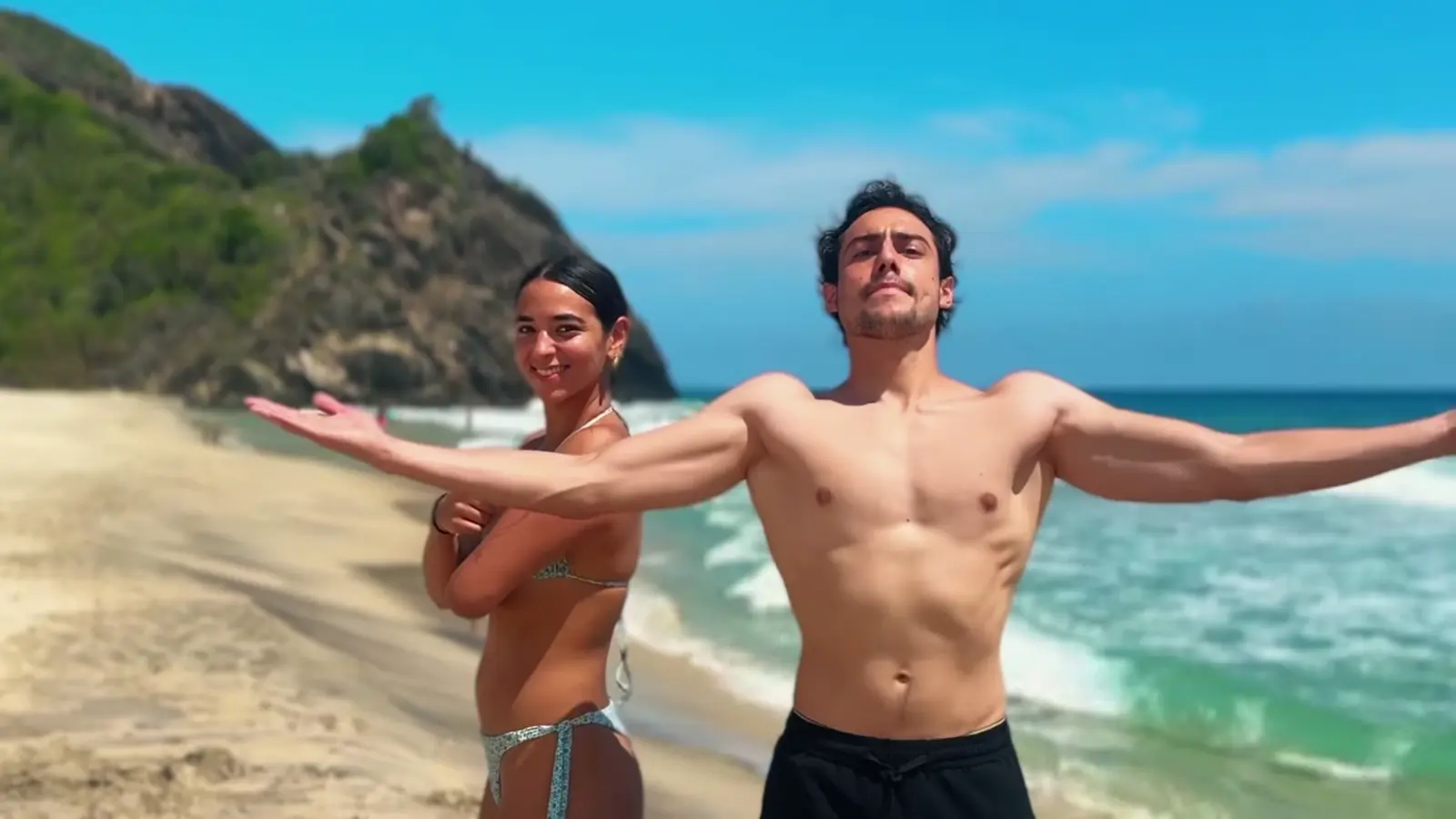 Cuyagua: dos creadores en la playa con las olas detrás.