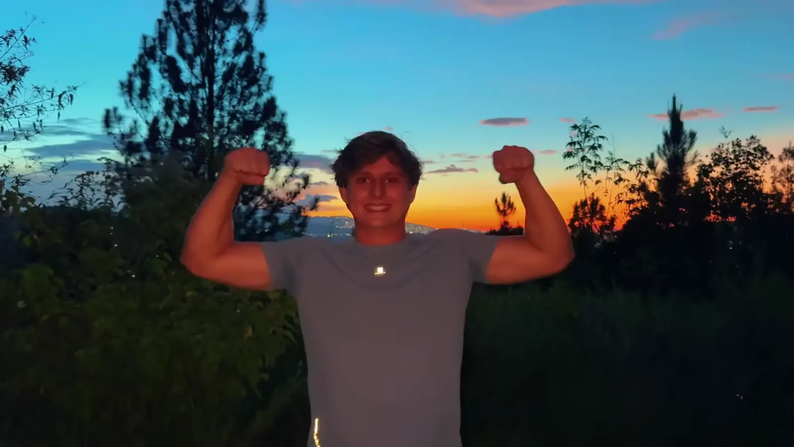 El Volcán: un creador levanta los brazos frente al atardecer naranja.