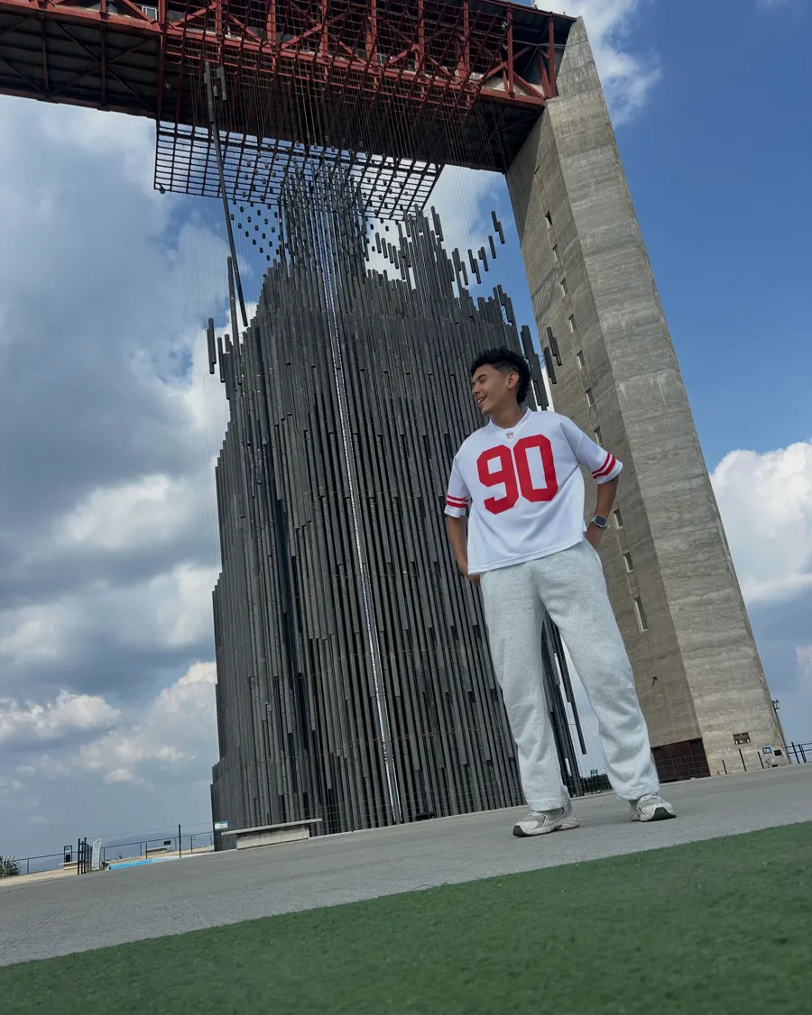 Dani con la camiseta 90 posa frente al monumento de Barquisimeto.